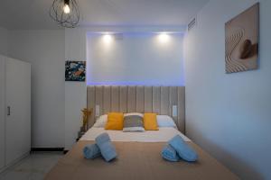 um quarto com uma cama grande e almofadas azuis em La Roca Chica em Torremolinos