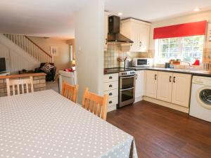 a kitchen with a table and a dining room at Beach Way Cottage in Gorran Haven
