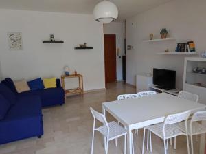 a living room with a blue couch and a table and chairs at Carla House in Celle Ligure