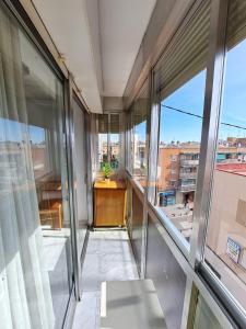 un balcón con puertas de cristal y una mesa con una planta en Piso céntrico y tranquilo, en Madrid