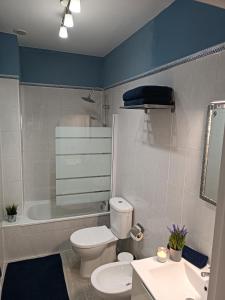 a bathroom with a toilet and a tub and a sink at Apartamento Soleado in Los Abrigos