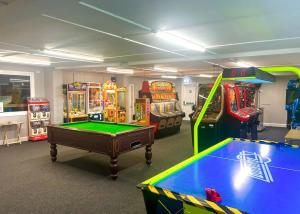 uma sala com vários jogos de arcada e uma mesa de bilhar em Burrowhead Holiday Village em Isle of Whithorn