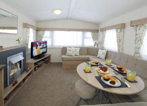 a living room with a table with food on it at Burrowhead Holiday Village in Isle of Whithorn