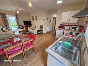 a kitchen and living room with a table and a sink at Burnt House Farm in Highbridge