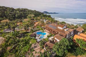 uma vista aérea de uma casa e do oceano em Hotel Nacional Inn Ubatuba - Praia das Toninhas em Ubatuba