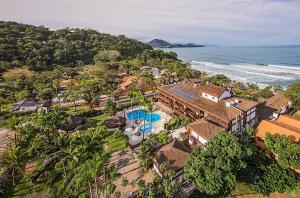 an aerial view of a house and the ocean at Hotel Nacional Inn Ubatuba - Praia das Toninhas in Ubatuba