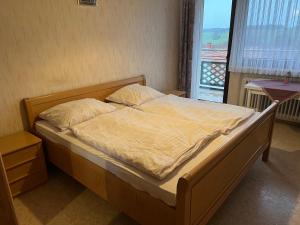 duże łóżko w pokoju z oknem w obiekcie Doppelzimmer Nr 5 w mieście Freiensteinau