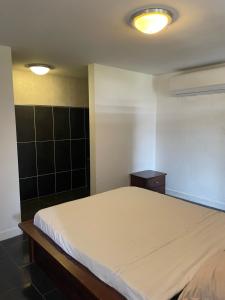 a bedroom with a large bed and two lights at Appart Damazonie T1BIS calme idéalement situé in Montjoly