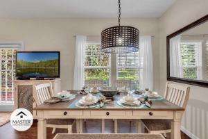 a dining room with a table with chairs and a television at 4 Bedrooms 3 Bathrooms Lucaya Village 15-101 in Orlando