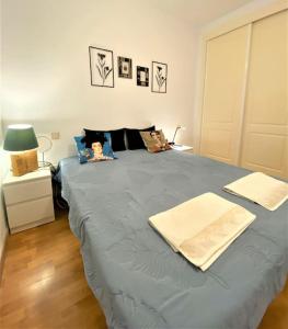 una camera da letto con un letto blu con due asciugamani di klimatyczny loft i egzotyczny basen a Benalmádena