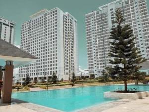 uma grande piscina numa cidade com edifícios altos em EMSMAR 908 Wind Residences Tagaytay em Tagaytay