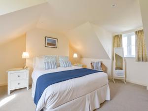 sypialnia z dużym białym łóżkiem z niebieską pościelą w obiekcie Duffield w mieście Kingsbridge
