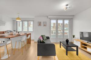 Il comprend une cuisine et un salon avec une table et un canapé. dans l'établissement Le Synopsis - Joli T3 avec garage, à Toulouse