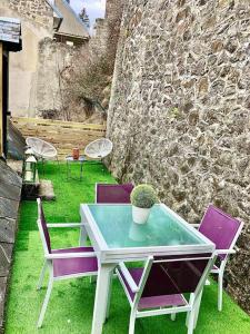 een tafel en stoelen met een potplant op een patio bij Maison de vacances in La Bourboule
