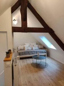 een zolderkamer met een bed en een tafel bij Maison de vacances in La Bourboule