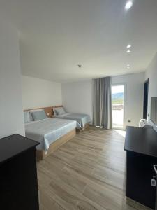 Habitación de hotel con 2 camas y TV en Hotel Verzaci, en Rinas