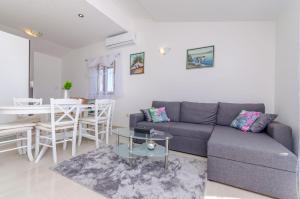 ein Wohnzimmer mit einem Sofa und einem Tisch in der Unterkunft Apartmani Selo Luka in Ražanj