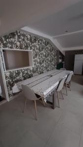 einen langen Tisch und Stühle in einem Zimmer mit einer Wand in der Unterkunft Maison T4 a 6 minutes à pieds de Sarlat in Sarlat-la-Canéda