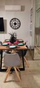 une salle à manger avec une table, des chaises et une horloge dans l'établissement Elegant Seaside 2 Floor Apartment, à Athènes