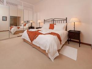 1 dormitorio con 1 cama grande y espejo en Bellavista, en Gansbaai