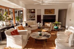 a living room with white furniture and a table at La Posada del Faro in José Ignacio