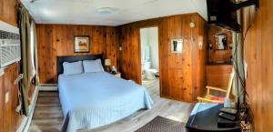 een slaapkamer met een bed in een kamer met houten wanden bij Riverside Motel in Lewiston