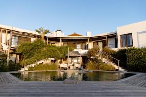 a building with a pond in front of a building at Posada del Faro in José Ignacio