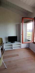 uma sala de estar com uma televisão e uma janela em LOGHINO Lombardo em Valdirame