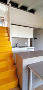 una cocina con armarios blancos y una escalera amarilla en LOGHINO Lombardo, en Valdirame