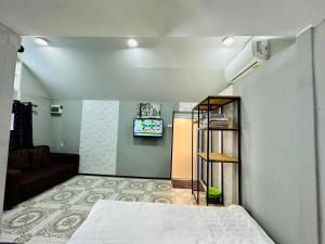 a bedroom with a bed and a tv on a wall at Keyman House Khao Yai in Pak Chong