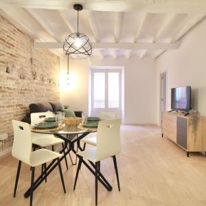 een woonkamer met een eettafel en stoelen bij Mediterranean Way - Cavaller Suites in Tarragona