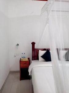 ein Schlafzimmer mit einem weißen Bett mit Baldachin in der Unterkunft Tantra Ella Lodge in Ella