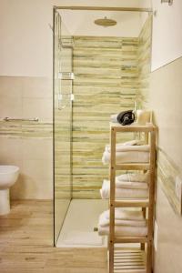 baño con ducha de cristal y una pila de toallas en Sale Hotel, en Posada