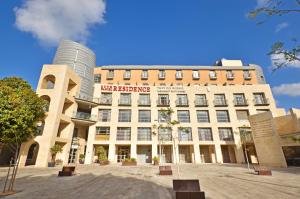 a large building with a sign on top of it at Ruth Daniel Residence in Tel Aviv