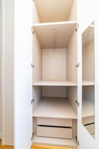 Cette chambre comprend un placard avec des étagères blanches. dans l'établissement Amaro I - Boutique 2 bed apartment in Alcantara, à Lisbonne