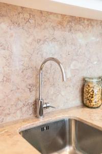 a kitchen sink with a faucet and a jar of peanuts at Amaro I - Boutique 2 bed apartment in Alcantara in Lisbon