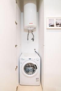 a washer and dryer in a white laundry room at Amaro I - Boutique 2 bed apartment in Alcantara in Lisbon