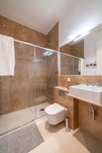 a bathroom with a toilet and a sink and a shower at Amaro I - Boutique 2 bed apartment in Alcantara in Lisbon
