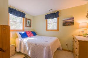 a bedroom with a bed and two windows at 131 #5 North Shore Boulevard East Sandwich -- Waters Edge #5 in East Sandwich