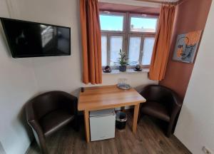 um quarto com uma mesa e duas cadeiras e uma televisão em Gasthof Goldener Stern em Iphofen