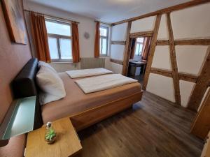 a small bedroom with a bed and a table at Gasthof Goldener Stern in Iphofen