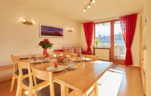 a dining room with a wooden table and red curtains at Haus Wendland in Bischofswiesen