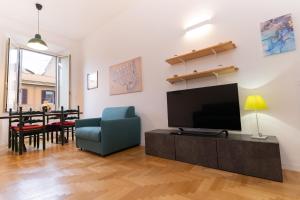 een woonkamer met een televisie en een blauwe stoel bij Scipioni Holiday House in Rome