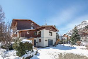 een huis in de winter met sneeuw op de grond bij Le Chalet in Les Deux Alpes