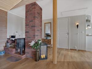 sala de estar con pilar de ladrillo y chimenea en Holiday home FINNÅS II, 