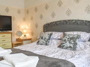 a bedroom with a bed and a tv on a dresser at Maureg Formby in Formby