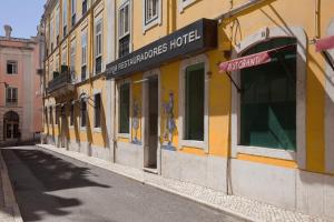 un edificio amarillo al lado de una calle en TURIM Restauradores Hotel, en Lisboa
