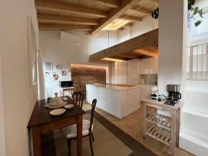 a kitchen and dining room with a table and chairs at La Piccola Casa al Lago - Intera casa con 3 camere e 2 box in Salò