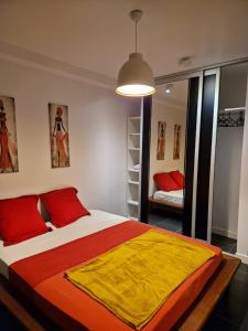 um quarto com uma cama grande com lençóis vermelhos e amarelos em Appart Damazonie T3 Idéalement situé em Montjoly