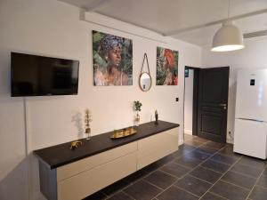 a kitchen with a black counter and a tv on the wall at Appart Damazonie T3 Idéalement situé in Montjoly